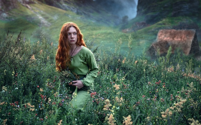 Redhead woman in green dress in a field