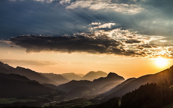 Sunset over misty mountains and valley with clouds