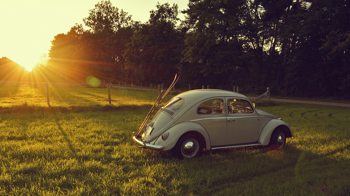 Vintage Volkswagen Beetle with skis at sunset