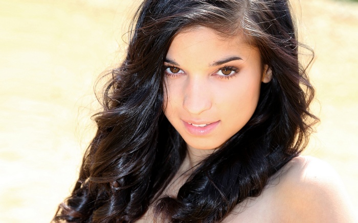 Nika with long dark wavy hair outdoors