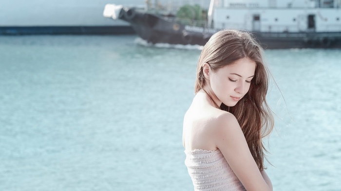 Woman with long auburn hair by the water