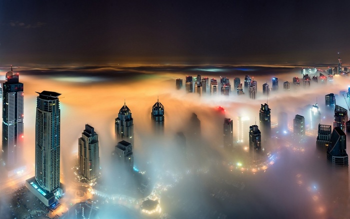 Dubai skyscrapers shrouded in mist at night