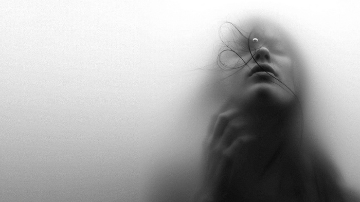 Woman's face obscured by smoke and hair