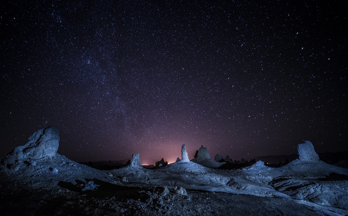 Starry night over desert rock formations