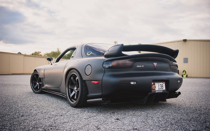Matte black Mazda RX-7 with a large rear spoiler