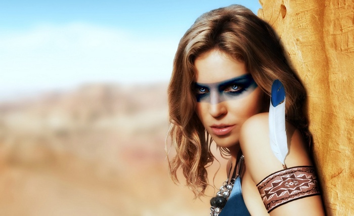 Woman with blue face paint and feather