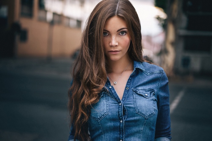 Woman in denim shirt with heart necklace