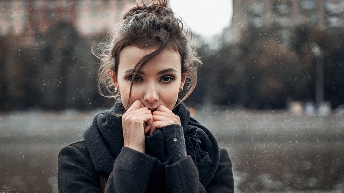 Woman with hair in face wearing scarf outdoors