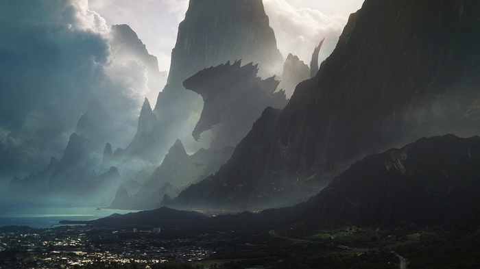 Godzilla silhouette among misty mountains overlooking a town