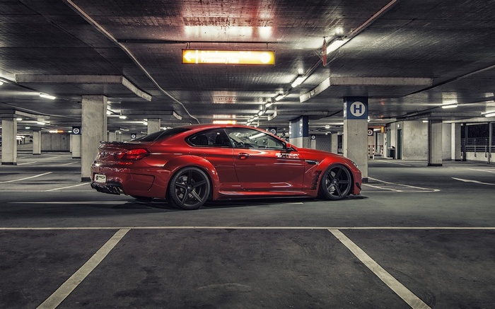 Red BMW M6 tuned car in a parking garage