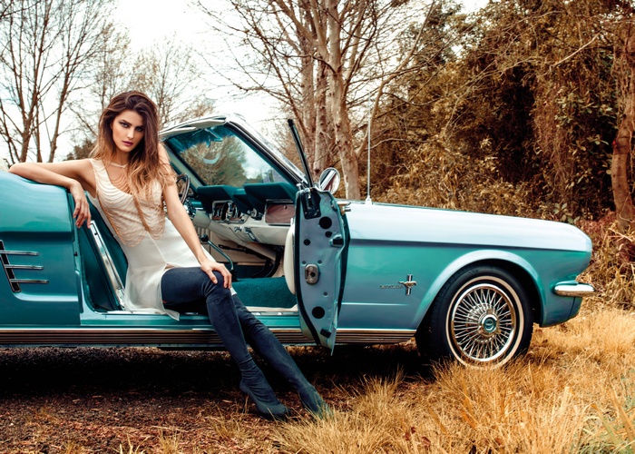 Woman in white dress and suede stockings with a classic car