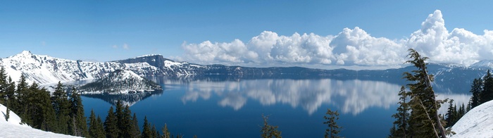 Crater Lake with snow-capped mountains and clouds