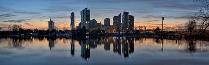 Vienna skyline reflected in the Danube River at dusk