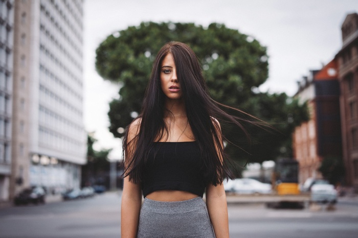 Woman in a black top and grey skirt in the city