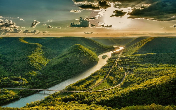 River valley with mountains and clouds at sunset