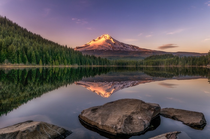 Snowy mountain reflected in a lake at sunset