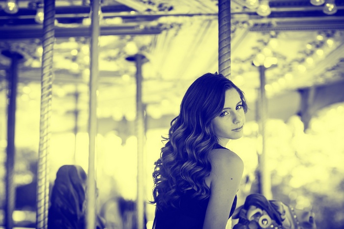 Woman on a carousel looking over her shoulder