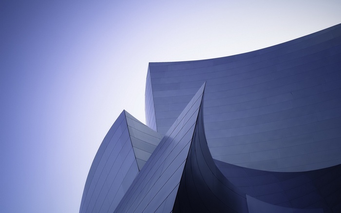 Modern building with curved metallic facade against clear sky