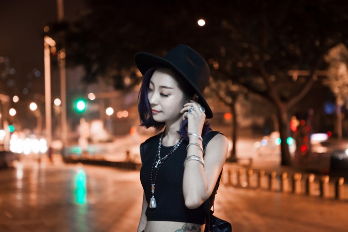 Asian woman with purple hair wearing a hat and necklace