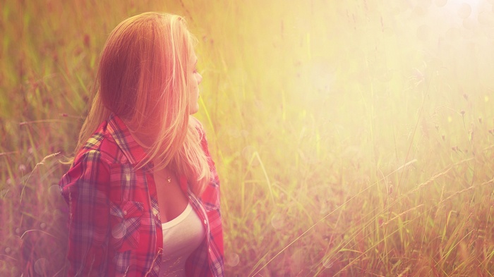 Woman in a red plaid shirt in a field