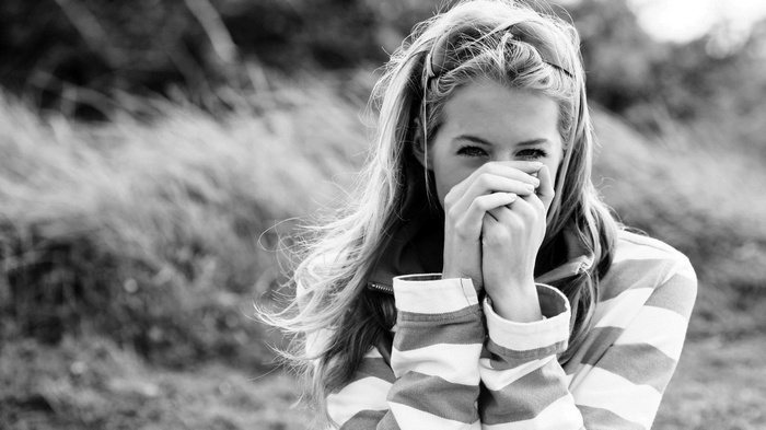 Monochrome portrait of a young woman covering her mouth