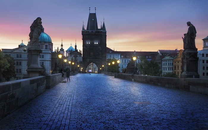 Charles Bridge in Prague at dawn with statues and tower