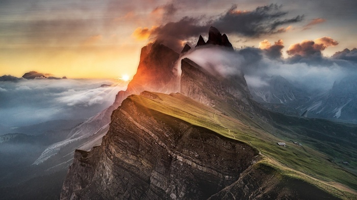 Sunset over misty mountains with dramatic clouds