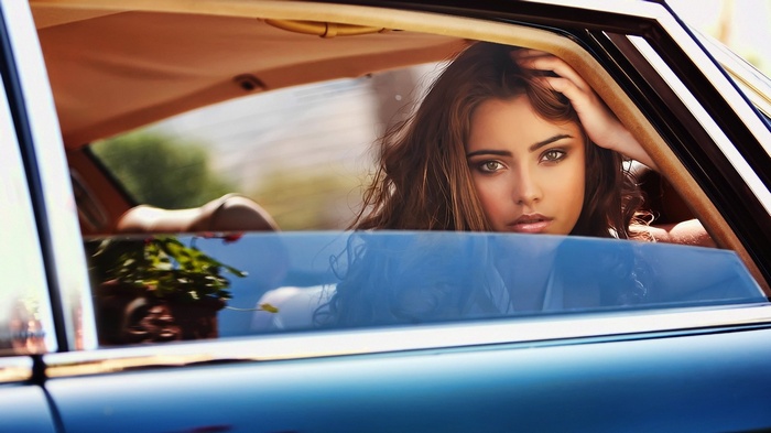 Woman with hand on head in car