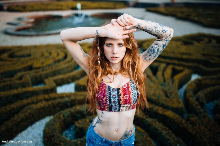 Portrait of a tattooed redhead woman in jean shorts