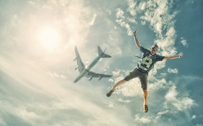 Man jumping in the sky with an airplane