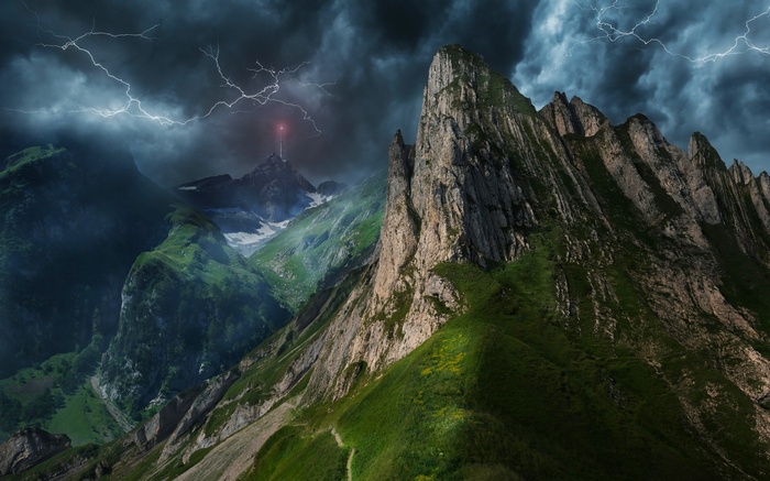 Stormy mountain landscape with lightning and mist