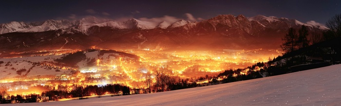 Winter night landscape of a town in Poland with mountains