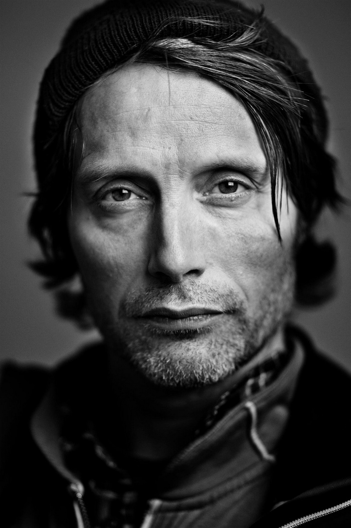 Mads Mikkelsen wearing a beanie in a monochrome portrait