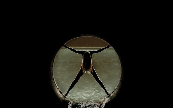 Woman stretching in a circular tunnel with water