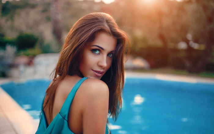 Woman with long hair by a swimming pool