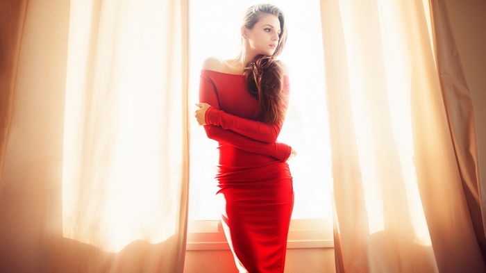 Woman in red dress by window