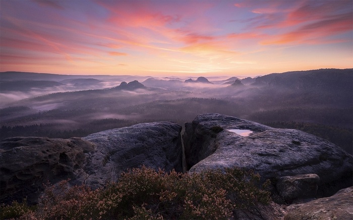 Misty mountains at sunrise with pink clouds
