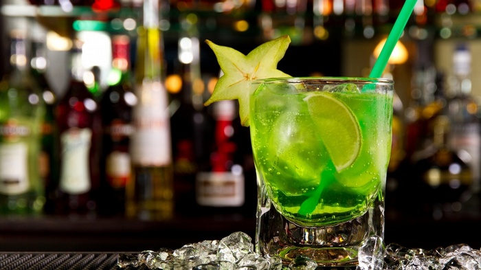 Green cocktail with star fruit and lime on ice