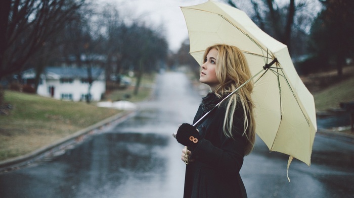 Woman with blonde hair holding an umbrella in the rain