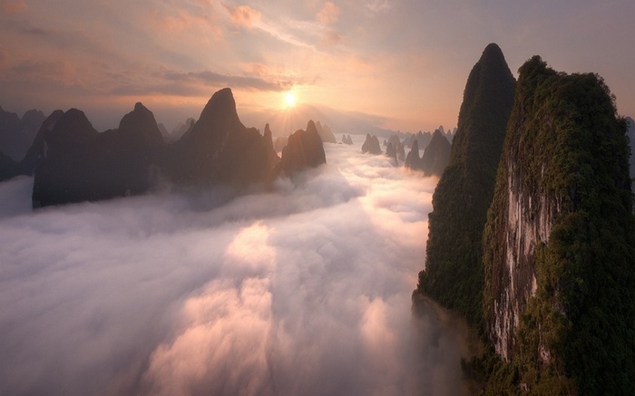 Karst mountains in China covered in mist at sunrise