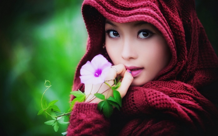 Asian woman in red hood holding a flower