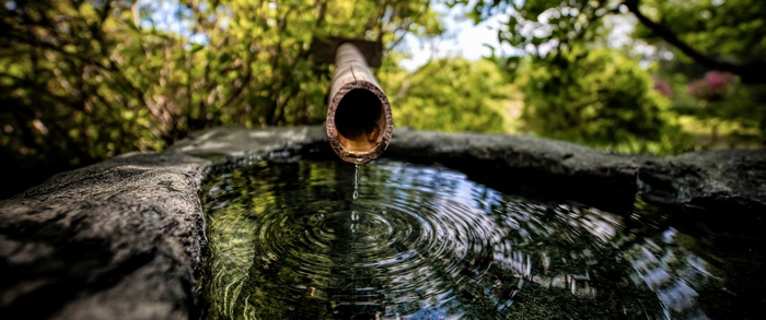 Water dripping from bamboo into a stone basin