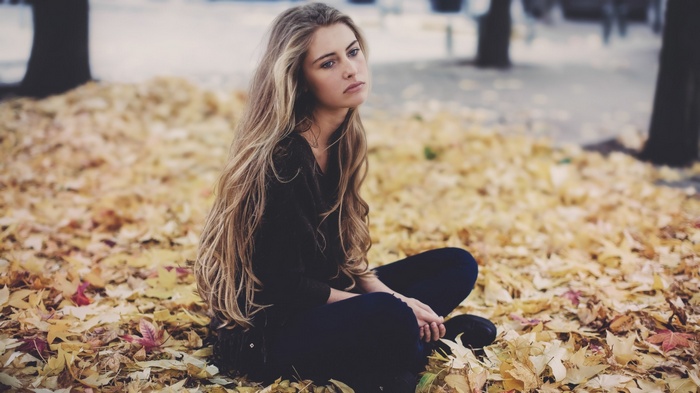 Camille Rochette sitting on autumn leaves