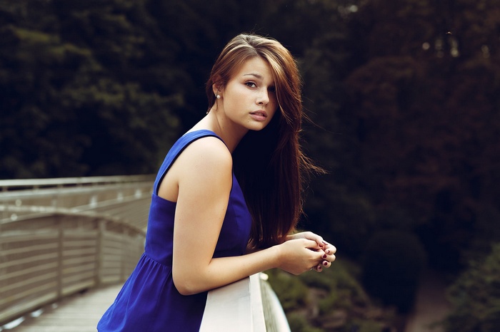 Woman in blue dress on a bridge