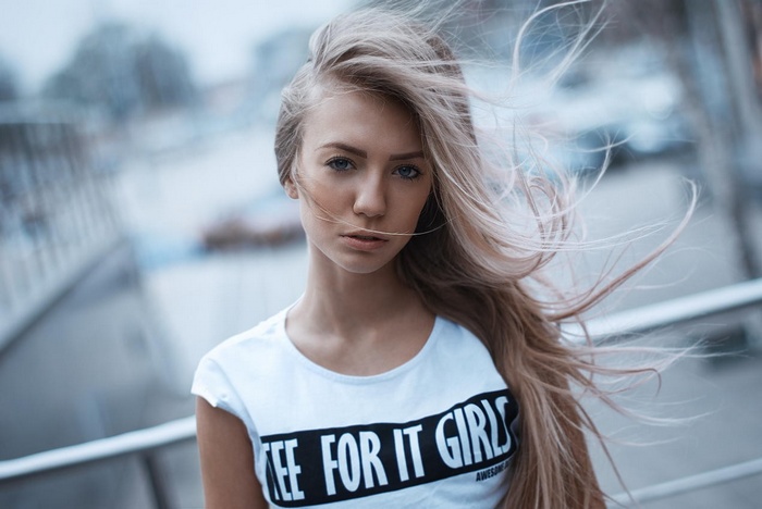 Woman with blonde hair wearing a white t-shirt