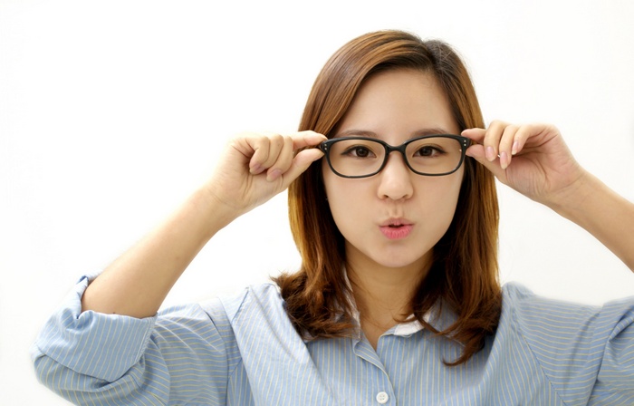 Asian woman with glasses makes a funny face