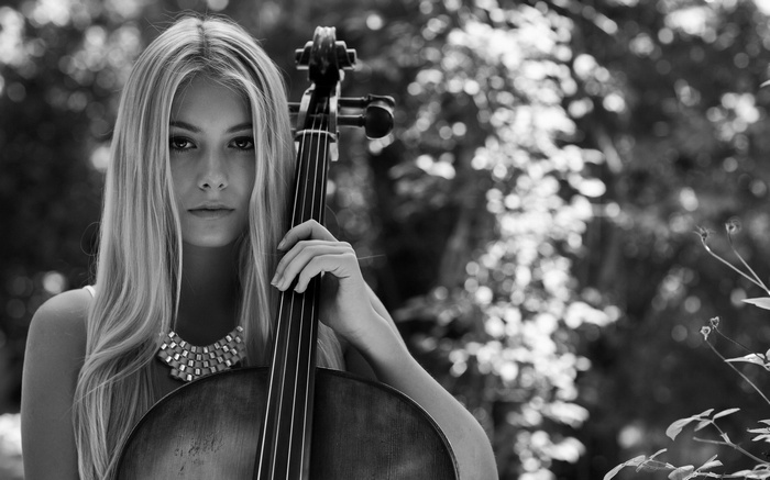 Woman with blonde hair playing cello outdoors