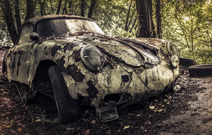 Abandoned vintage race car in a forest