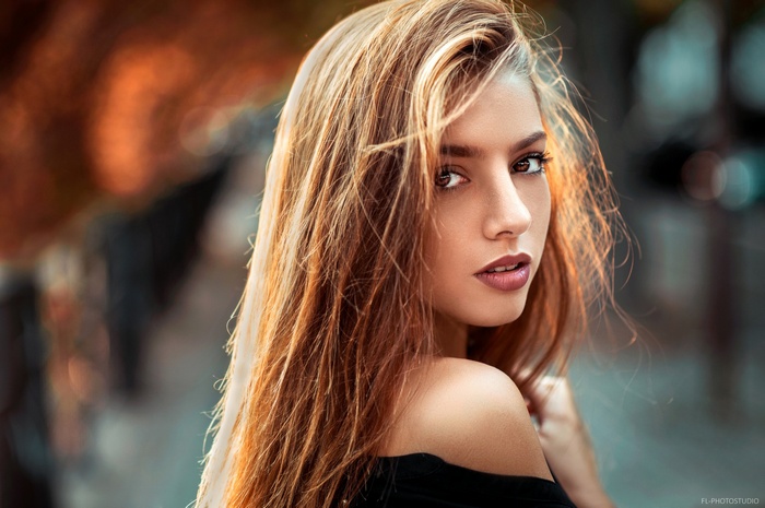 Woman with auburn hair looking over her shoulder
