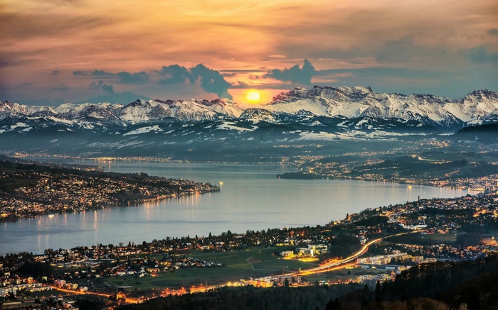 Zurich cityscape and snowy mountains at sunset
